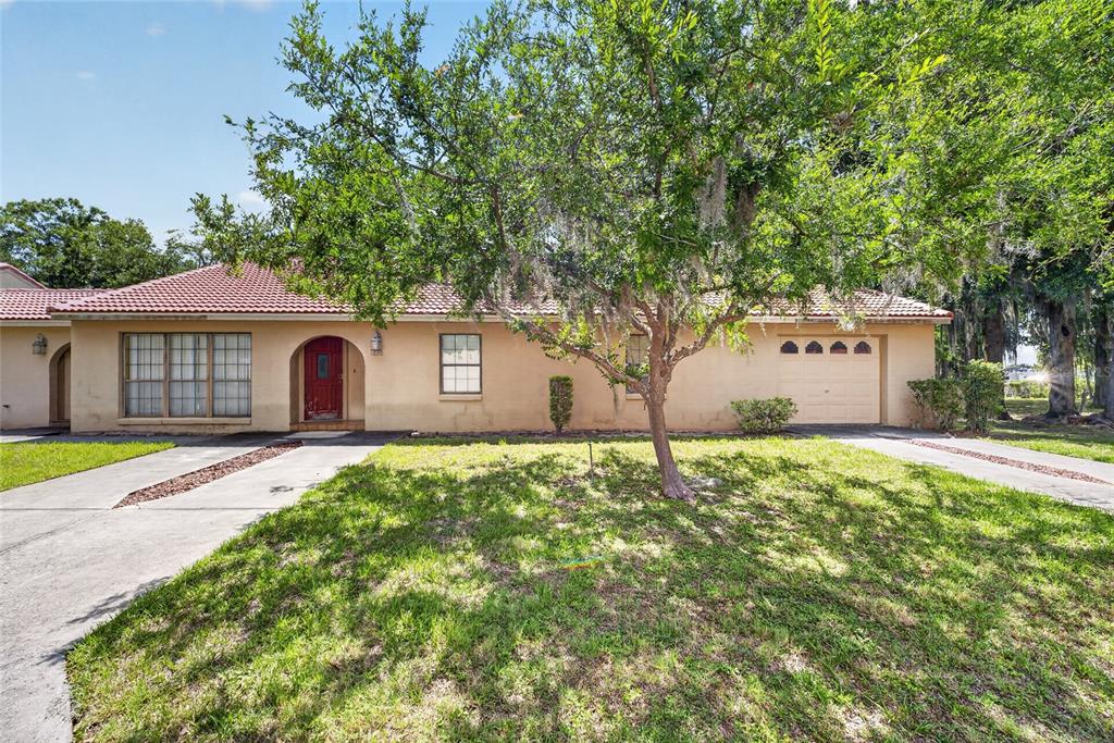 A single-story house with a red tile roof, beige stucco exterior, and a front tree — 1820 SW 35TH AVENUE, OCALA, FL