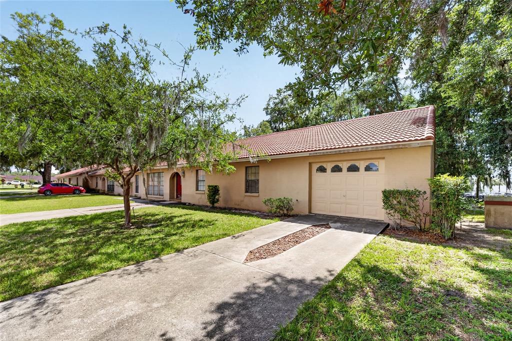 A single-story house with a tan stucco exterior, tile roof, and an attached garage — 1820 SW 35TH AVENUE, OCALA, FL