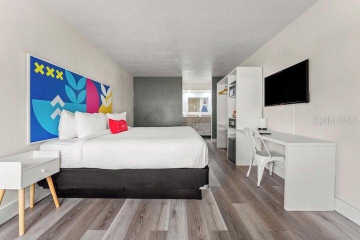 A hotel reception area features two wooden desks with computers against a colorful graphic wall — 2930 POLYNESIAN ISLE BOULEVARD UNIT 245, KISSIMMEE, FL