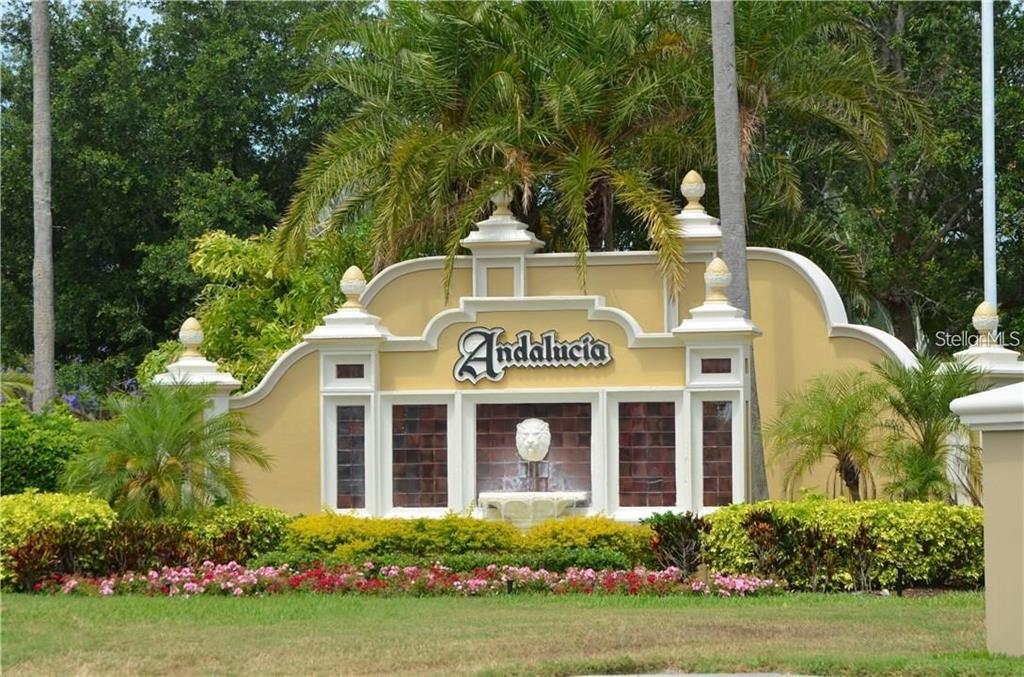 A decorative stucco entrance sign for the Andalusia community features a central lion head fountain — 5913 LA ROSA LANE, APOLLO BEACH, FL