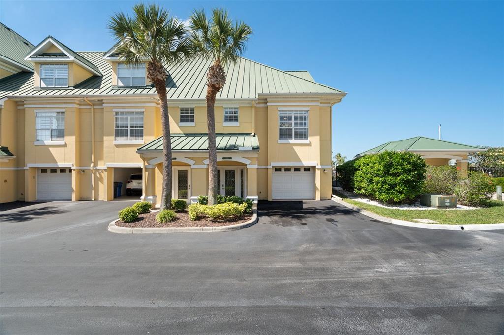 A yellow multi-unit building with a green metal roof and two palm trees in front — 6420 SUNSET BAY CIRCLE, APOLLO BEACH, FL