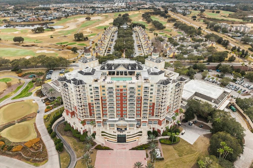 An aerial view shows a large hotel building surrounded by a golf course and parking — 7593 GATHERING DRIVE UNIT 1005, REUNION, FL