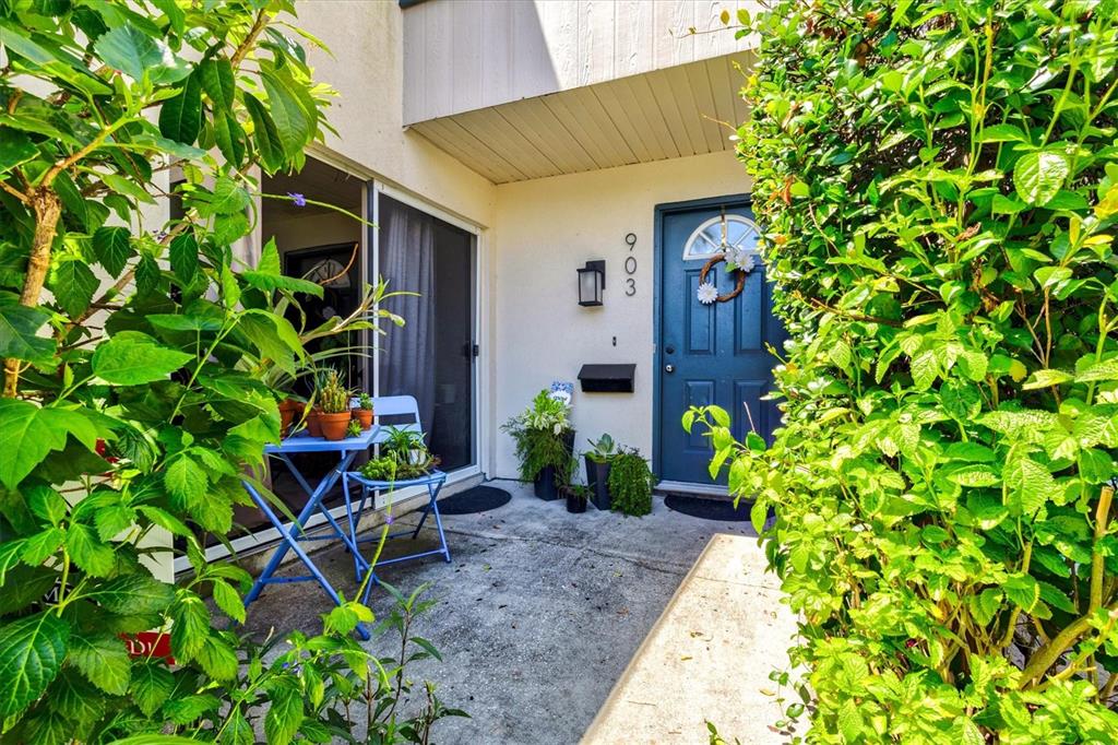 A blue front door and a small patio with a table and chairs — 903 BYRON LANE, SARASOTA, FL