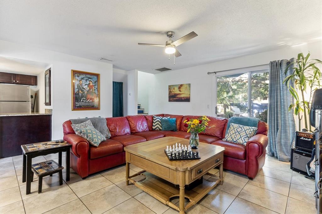 A living room features a large red sectional sofa, a wooden coffee table, and tile flooring — 903 BYRON LANE, SARASOTA, FL