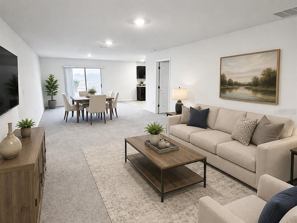 A living room and dining area feature neutral carpet, beige furniture, and a sliding glass door — 288 TOWNS CIRCLE, HAINES CITY, FL