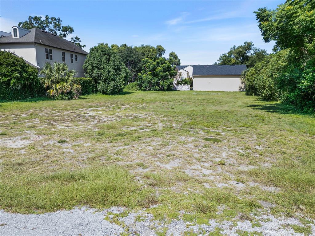A vacant, grassy residential lot is surrounded by trees and neighboring houses — 503 N INTERLACHEN AVENUE, WINTER PARK, FL