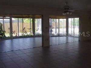 A room with tiled floors and large sliding glass doors looking out onto a fenced yard — 3041 TYRONE LANE, SARASOTA, FL