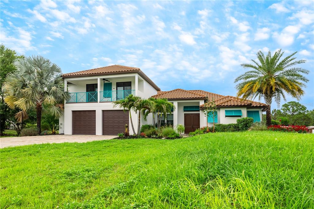 A two-story house with a tile roof, two garage doors, and a second-floor balcony — 7065 BRANCH COURT, ST CLOUD, FL