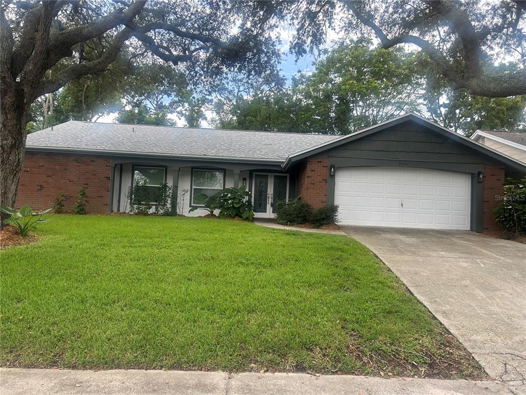 A single-story house with a brick and white exterior, a large tree, and two mailboxes — 8604 MILL CREEK LANE, HUDSON, FL