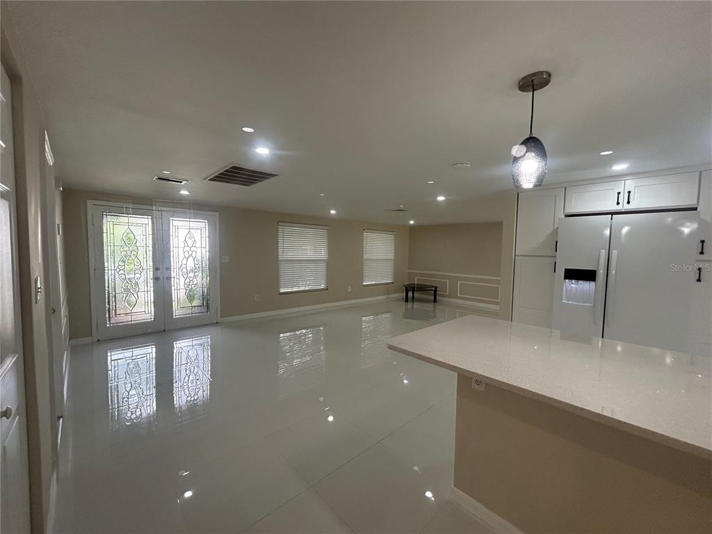 An entryway features white tile floors, beige walls with wainscoting, and double glass-paneled front doors — 8604 MILL CREEK LANE, HUDSON, FL