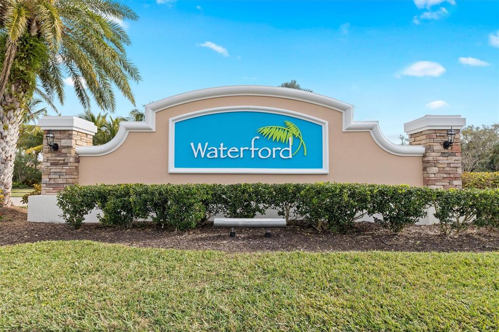 A stone and stucco monument sign for Waterford sits in front of a manicured lawn — 7466 W LENOX CIRCLE, PUNTA GORDA, FL