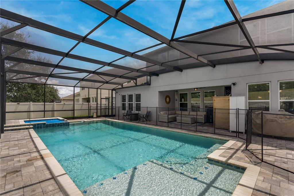 A screened-in swimming pool and patio area with outdoor seating and a fenced backyard — 14567 CEDAR HILL DRIVE, WINTER GARDEN, FL