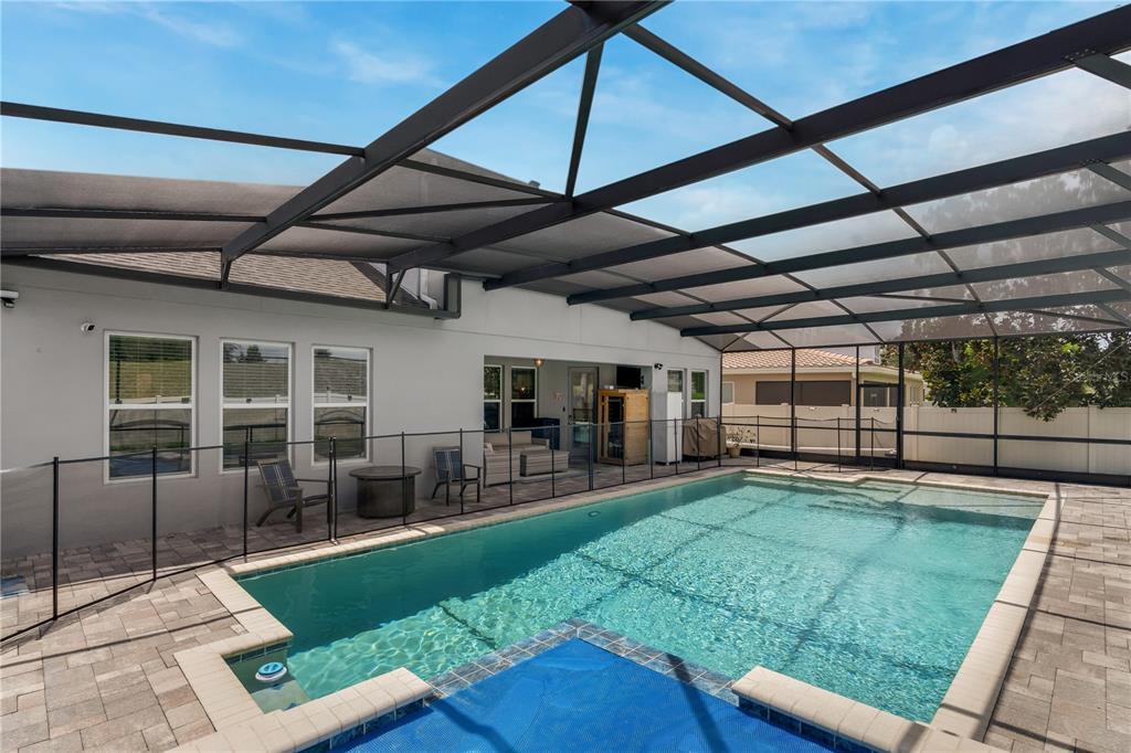 A screened-in patio features a swimming pool with a safety fence and paver decking — 14567 CEDAR HILL DRIVE, WINTER GARDEN, FL