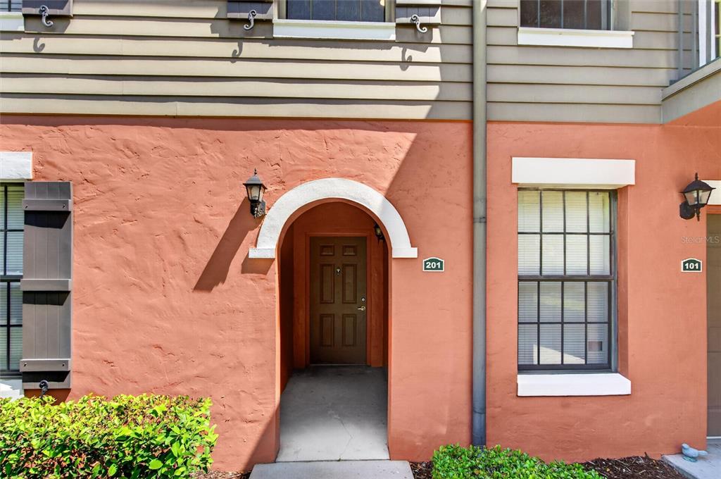 The exterior of a building features a brown door labeled 201 and a window labeled 101 — 760 CENTERVALE DRIVE UNIT 201, CELEBRATION, FL