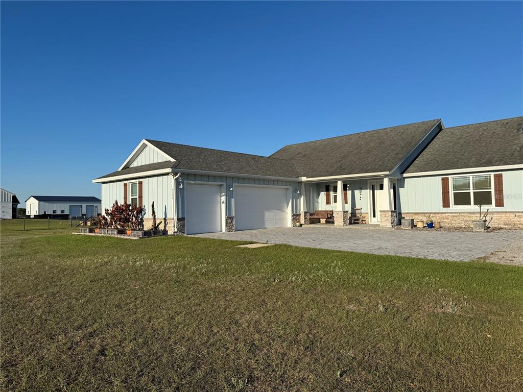 A light blue house with a stone base, two garage doors, and a paved driveway — 4155 ALBRITTON ROAD, ST CLOUD, FL