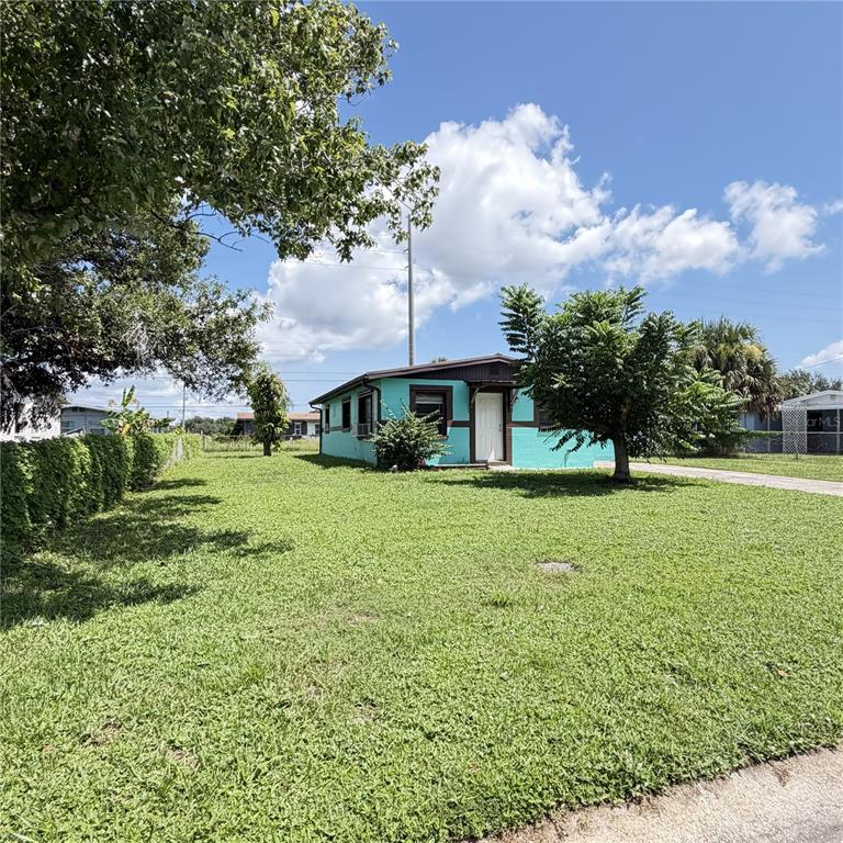 A turquoise single-story house with a brown roof sits on a large, grassy lot — 2884 TROPIC RD, MELBOURNE, FL