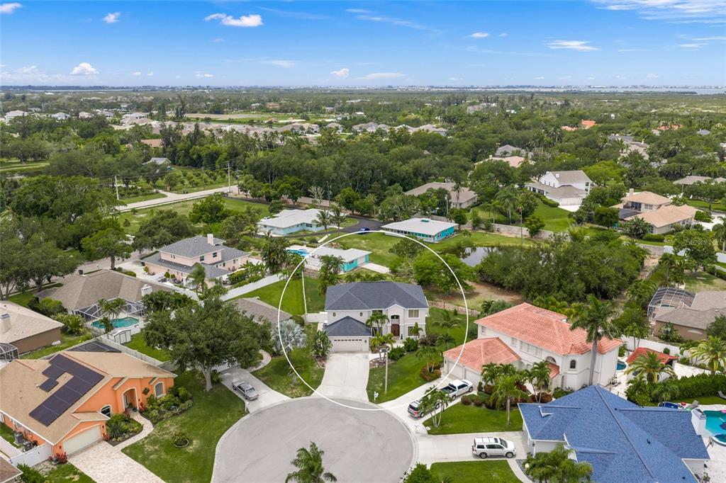 An aerial view shows a two-story house with a dark roof in a suburban neighborhood — 9214 18TH DRIVE NW, BRADENTON, FL