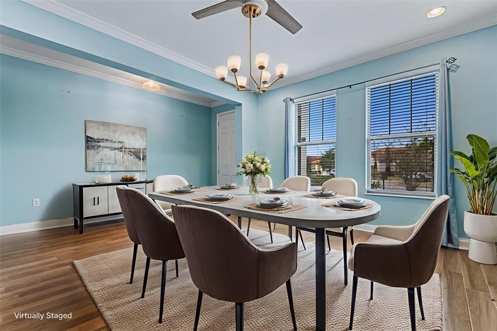 A dining room features a light blue wall, a modern chandelier, and a six-person table — 281 ANCONA AVENUE, DEBARY, FL