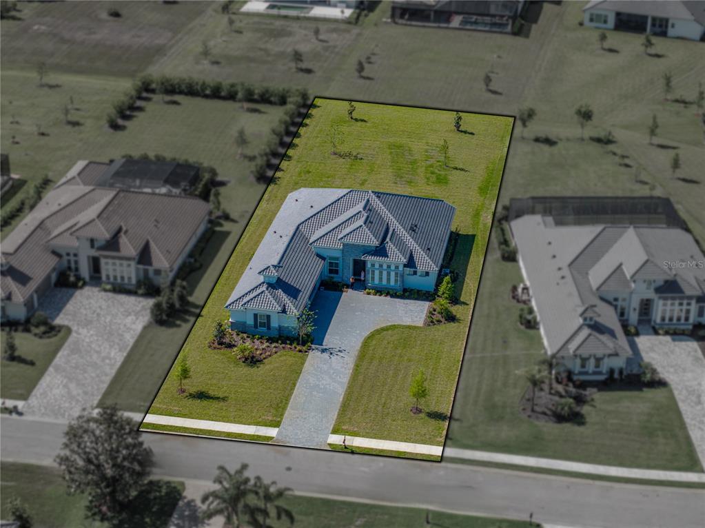 An aerial view shows a single-story house with a tiled roof and a paved driveway — 13805 CARRYBACK DRIVE, DADE CITY, FL