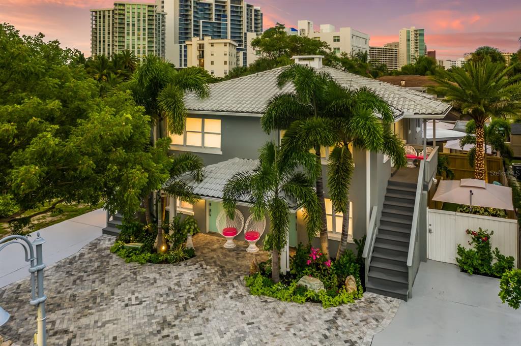 An exterior view of a two-story gray house with a tiled roof and palm trees — 161 GOLDEN GATE POINT, SARASOTA, FL