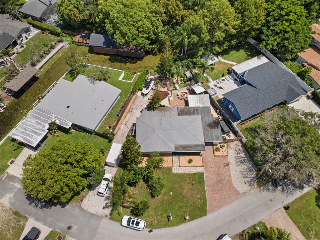An aerial view shows three houses with driveways, lawns, and mature trees in a neighborhood — 6809 WILLOUGHBY LANE, BELLE ISLE, FL