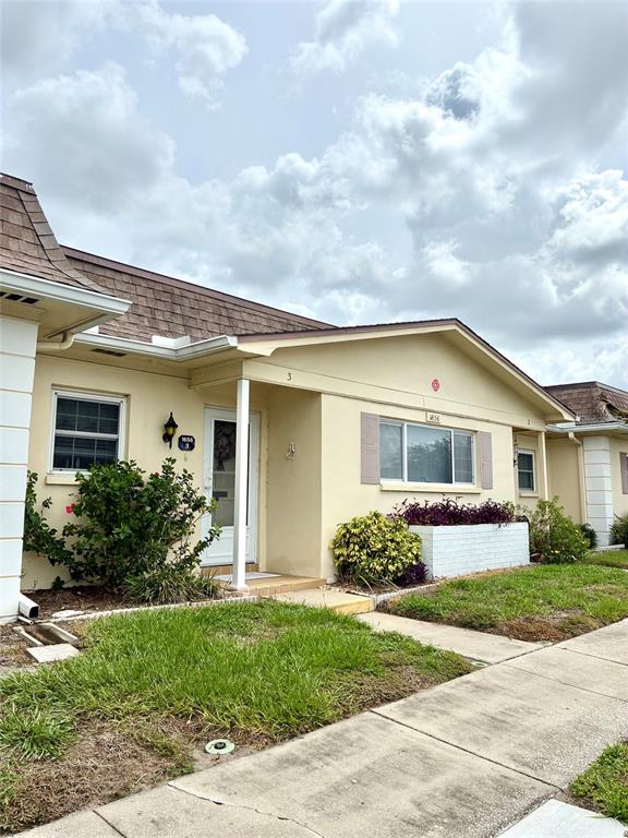 A kitchen features light wood cabinets, a white stove, a dishwasher, and a window — 1656 S LAKE AVENUE UNIT 3, CLEARWATER, FL