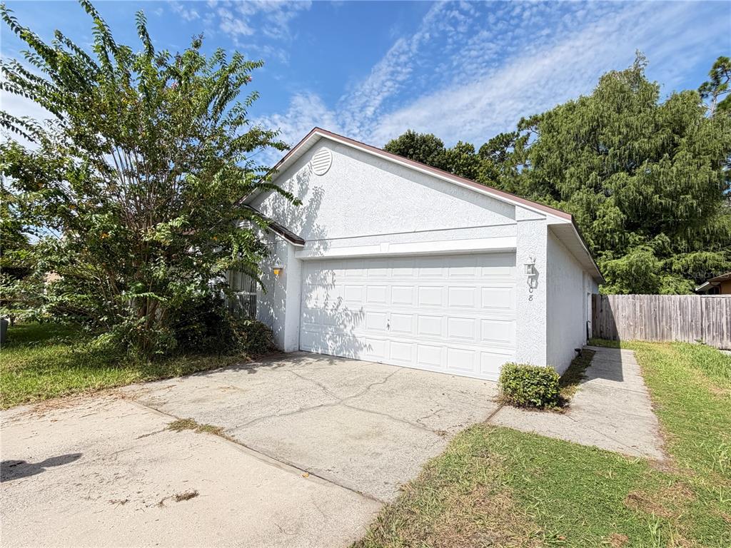 A white, single-story house with a two-car garage and a concrete driveway — 108 KAWILLA COURT, ORLANDO, FL