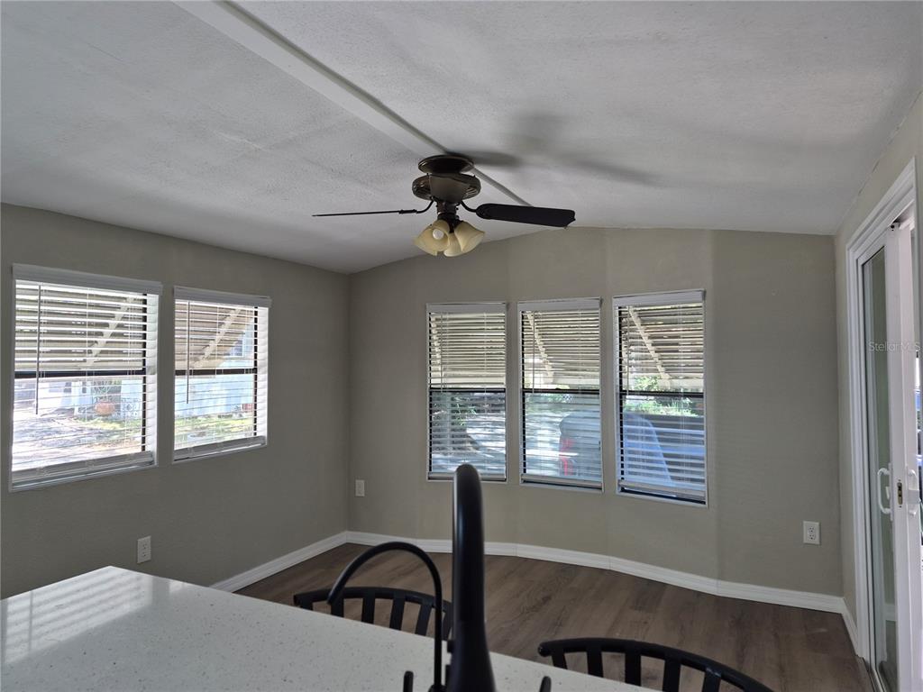 A dining area features light gray walls, wood-look flooring, a ceiling fan, and multiple windows — 3000 CLARCONA ROAD UNIT 532, APOPKA, FL