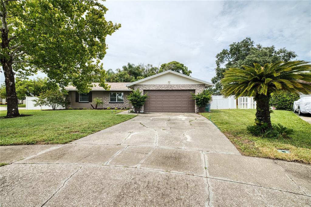 A single-story house with a stone facade, a two-car garage, and a cracked concrete driveway — 5331 OAK COURT, WINTER PARK, FL