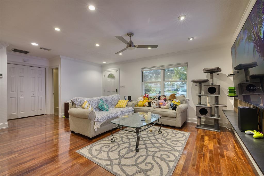 A living room features hardwood floors, a ceiling fan, a sofa with plush toys, and a rug — 5331 OAK COURT, WINTER PARK, FL