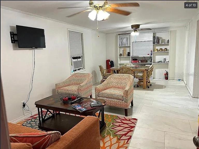 A living room features two patterned armchairs, a coffee table, and a dining area beyond — 1735 TIMOCUAN WAY, LONGWOOD, FL