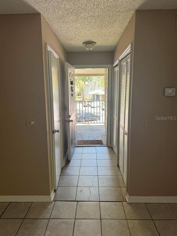An interior view shows a tiled entryway with a doorway leading to an outdoor space — 5962 WESTGATE DRIVE UNIT 204, ORLANDO, FL