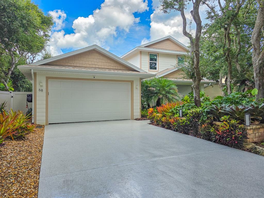 A two-story house with a garage, gravel landscaping, and large trees in the front yard — 68 GLENVIEW AVENUE, PONCE INLET, FL
