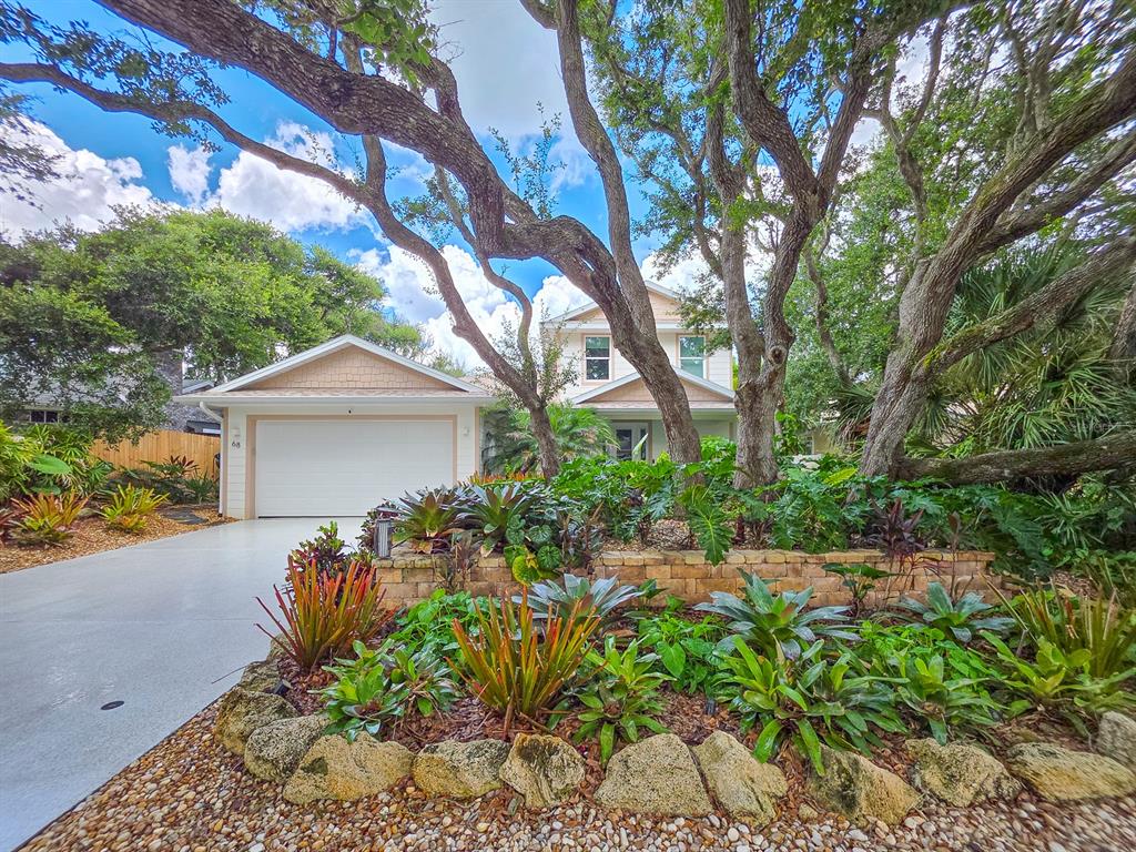 A two-story house with a white garage, a concrete driveway, and mature trees — 68 GLENVIEW AVENUE, PONCE INLET, FL
