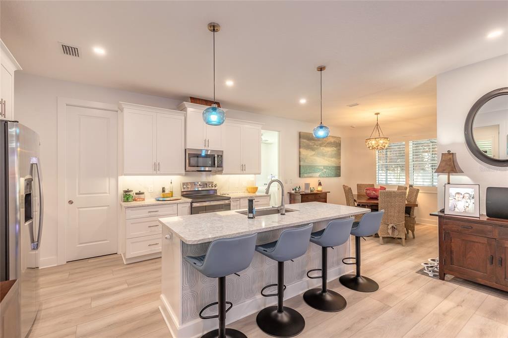 A light-colored house exterior features a front porch, a garage, and landscaped garden beds — 68 GLENVIEW AVENUE, PONCE INLET, FL