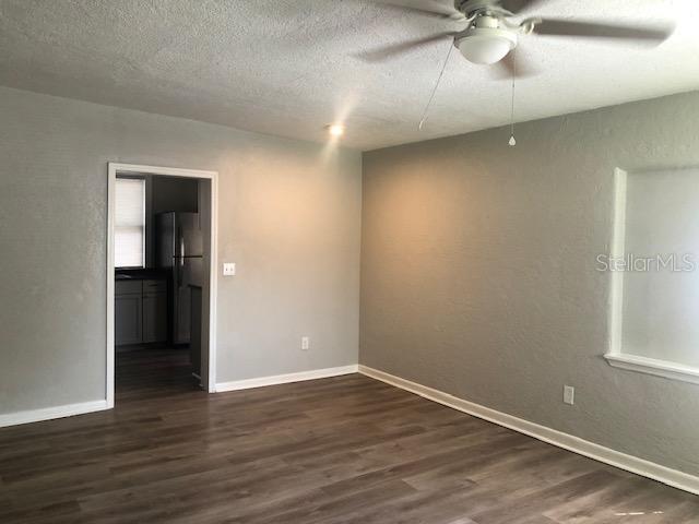 An empty room with gray walls, wood-look flooring, and a ceiling fan — 106 E 12TH STREET, SANFORD, FL