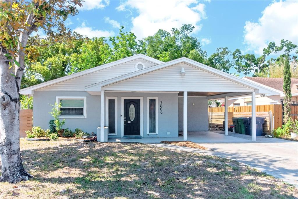 A single-story house with a light gray exterior, a front porch, and a carport — 3608 W CARMEN STREET, TAMPA, FL