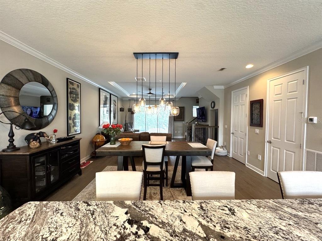 A kitchen and dining area with light cabinetry, a central island, and a pendant light fixture — 1487 LAKE GEORGE DRIVE, LAKE MARY, FL