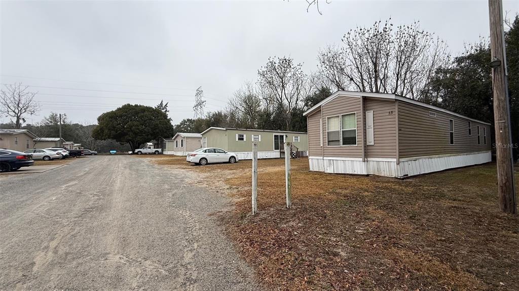 A gravel road runs past several mobile homes on a cloudy day — 12656 SE 78TH TERRACE, BELLEVIEW, FL
