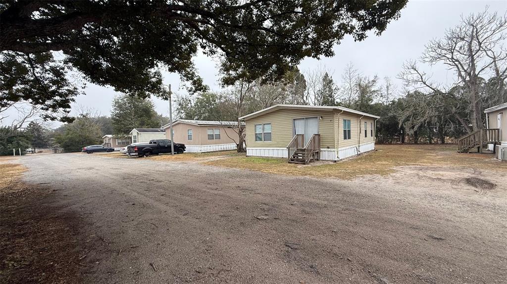 A gravel road leads past several manufactured homes under a large tree — 12656 SE 78TH TERRACE, BELLEVIEW, FL