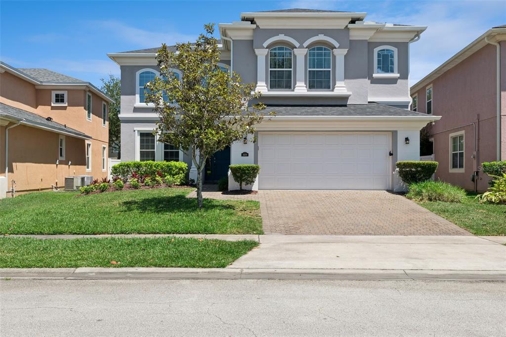 A two-story gray house with white trim, a front lawn, and a paved driveway — 509 SPRING RIVER DRIVE, ORLANDO, FL