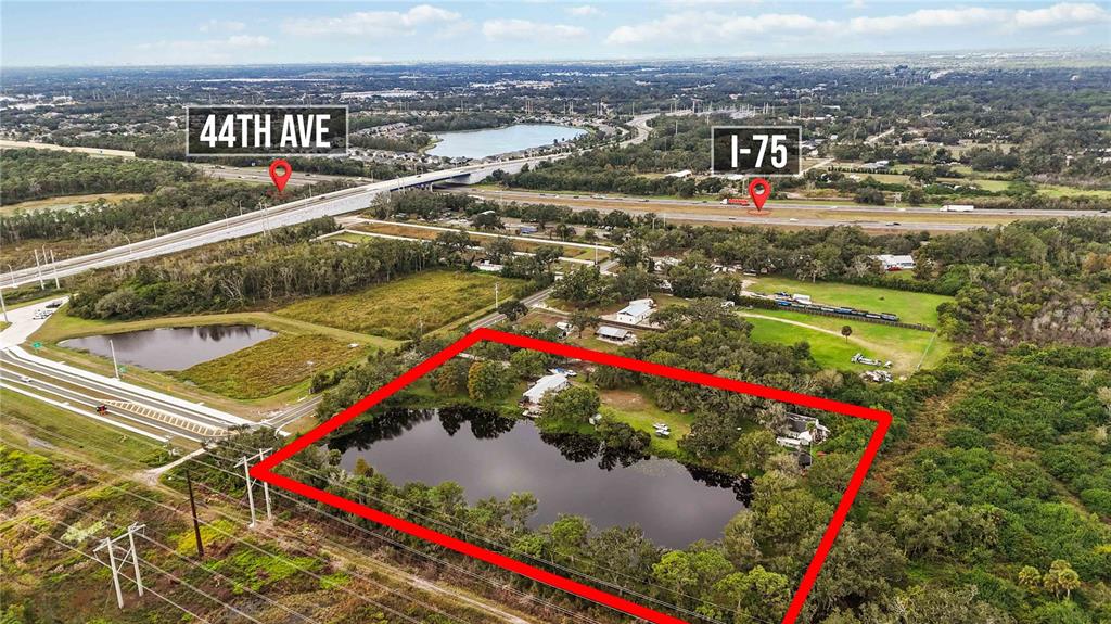 An aerial view shows a rectangular property boundary highlighting a pond and several small buildings — 8011 41ST AVENUE E, BRADENTON, FL