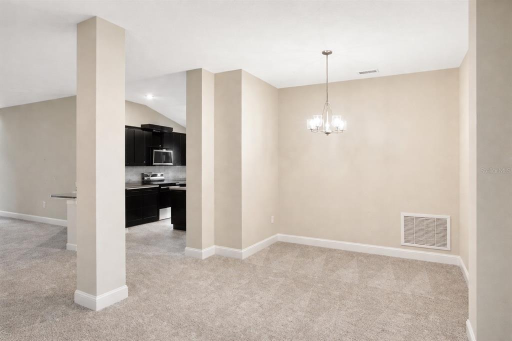 A kitchen features dark cabinets, granite countertops, stainless steel appliances, and a central island — 7544 BENT TREE LOOP, ST CLOUD, FL