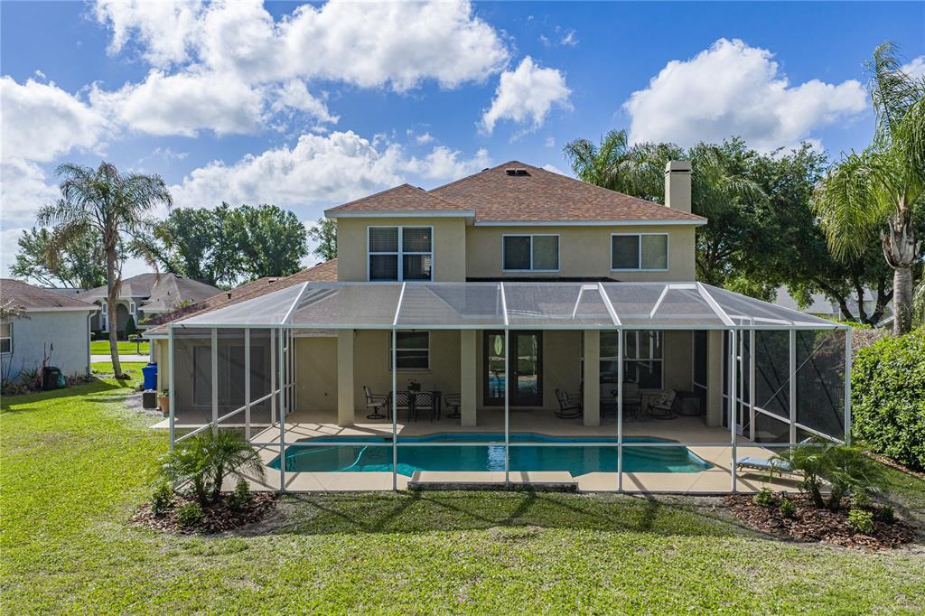 A two-story house features a screened-in pool and patio area in the backyard — 5104 WHISPERING LEAF TRAIL, VALRICO, FL