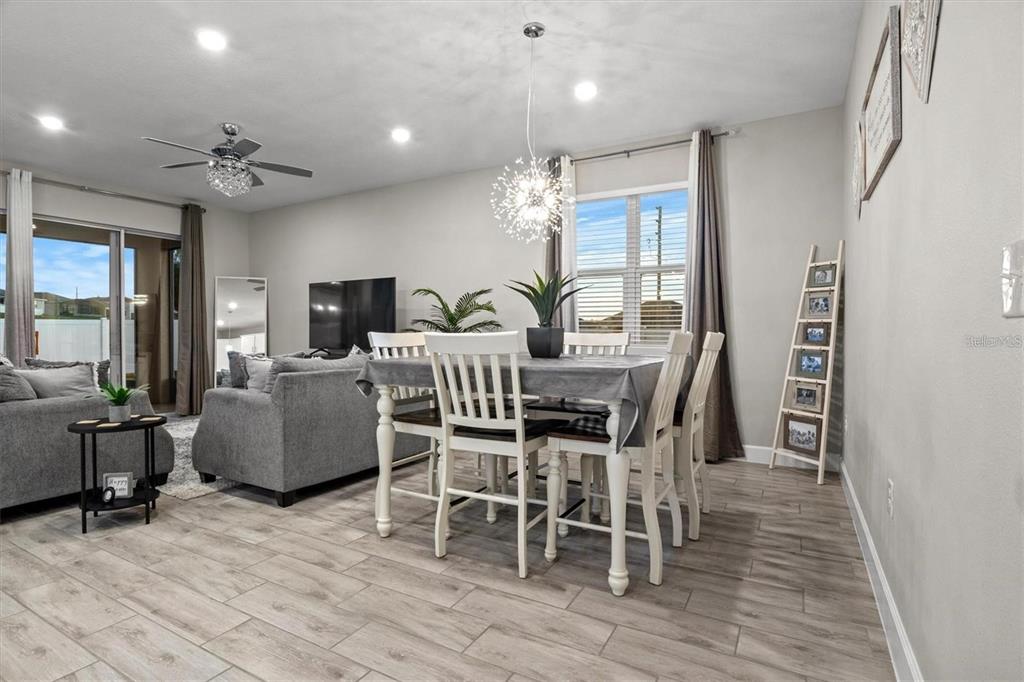 A dining area with a white table and chairs sits adjacent to a living room — 1804 VISTA VIEW DRIVE, DUNDEE, FL