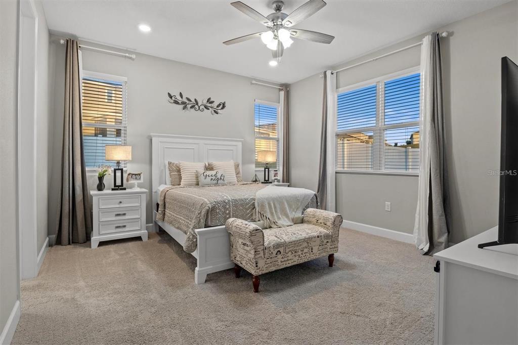 A bedroom features a white bed, a patterned bench, and a ceiling fan — 1804 VISTA VIEW DRIVE, DUNDEE, FL