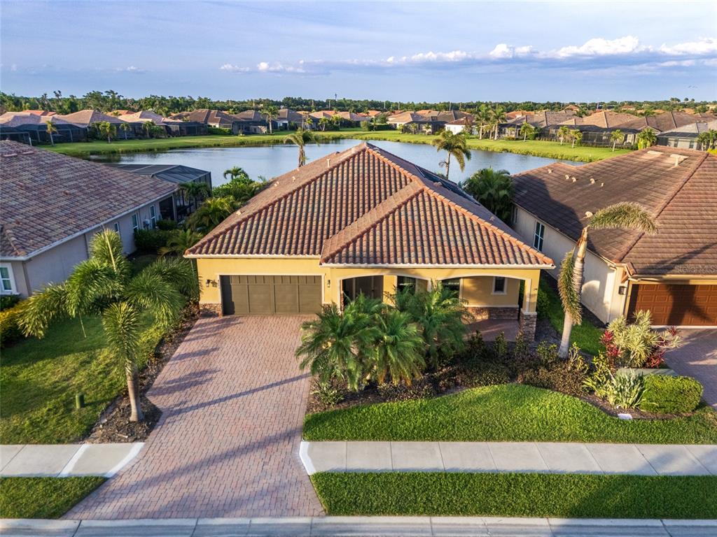 An aerial view of a single-story house with a tiled roof and a paved driveway — 4703 TOBERMORY WAY, BRADENTON, FL