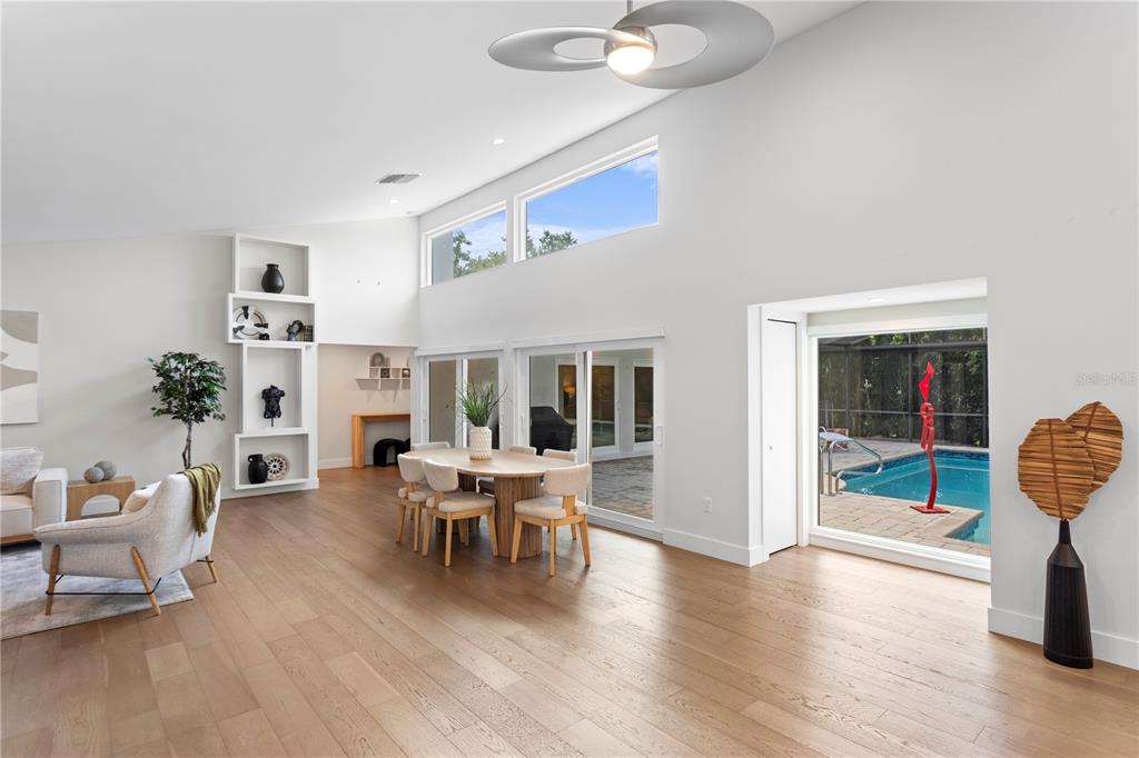 An open double door reveals a view through a home to a backyard swimming pool — 1428 PINE BAY DRIVE, SARASOTA, FL