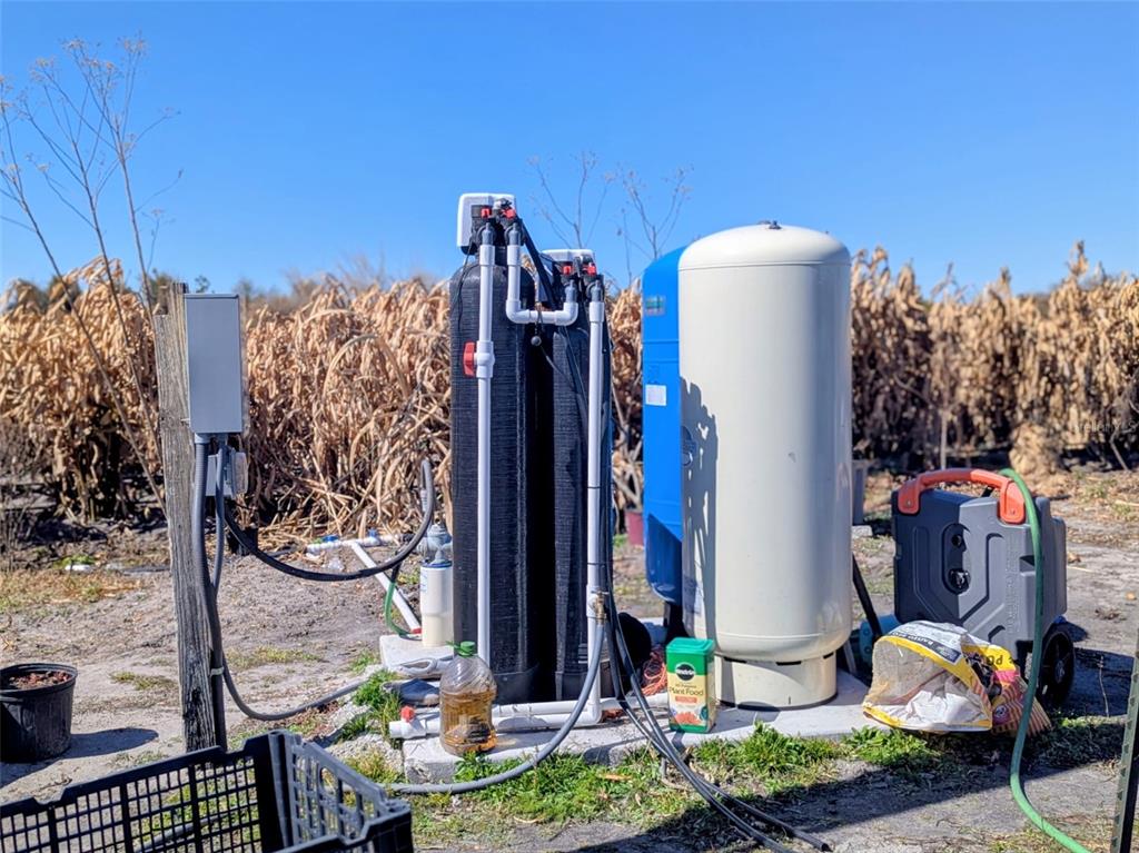 A water filtration system and pressure tank stand on a concrete pad outdoors — 46683 PEEPLES LANE, WAUCHULA, FL