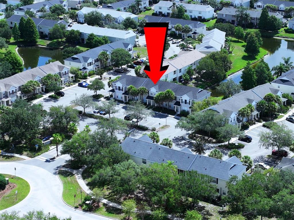 An aerial view shows a multi-unit townhouse complex with parking lots and surrounding green space — 12207 COUNTRY WHITE CIRCLE, TAMPA, FL